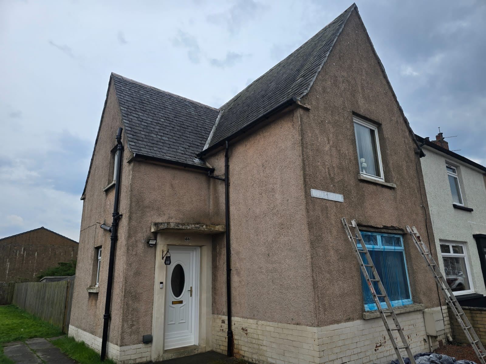 Before — weathered brown roughcast home